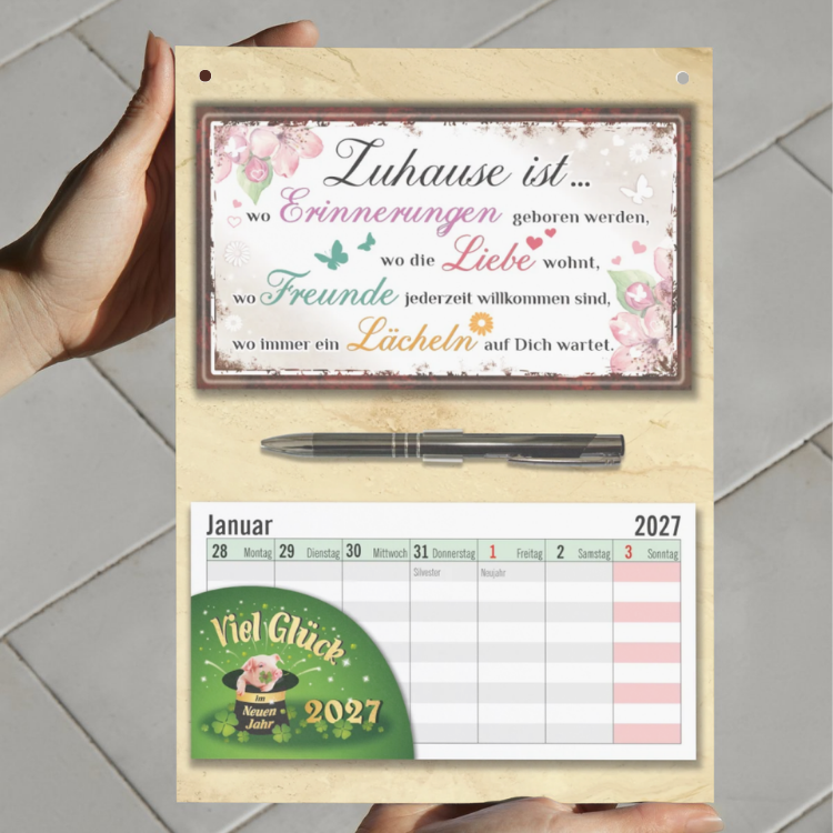 Geschenk zum Einzug Wandkalender 2027 – Einweihungsgeschenk Set mit Zuhause ist... Schild, Wochenplaner zum Abreißen & Metall-Kugelschreiber - in der hand